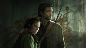 Ellie and Joel stand in front of a wall with cordyceps growing on it from The Last of Us HBO show