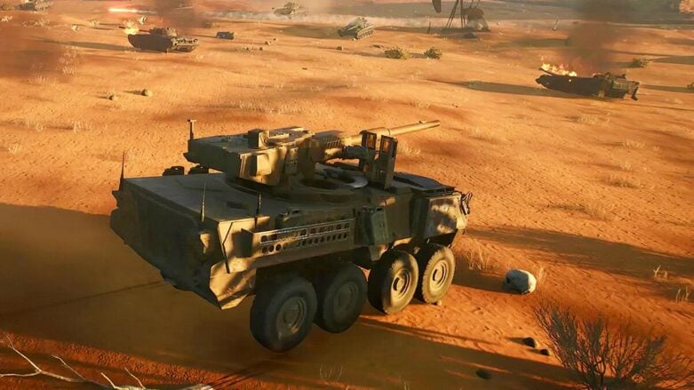 Os tanques da frente atirando em outros tanques no deserto