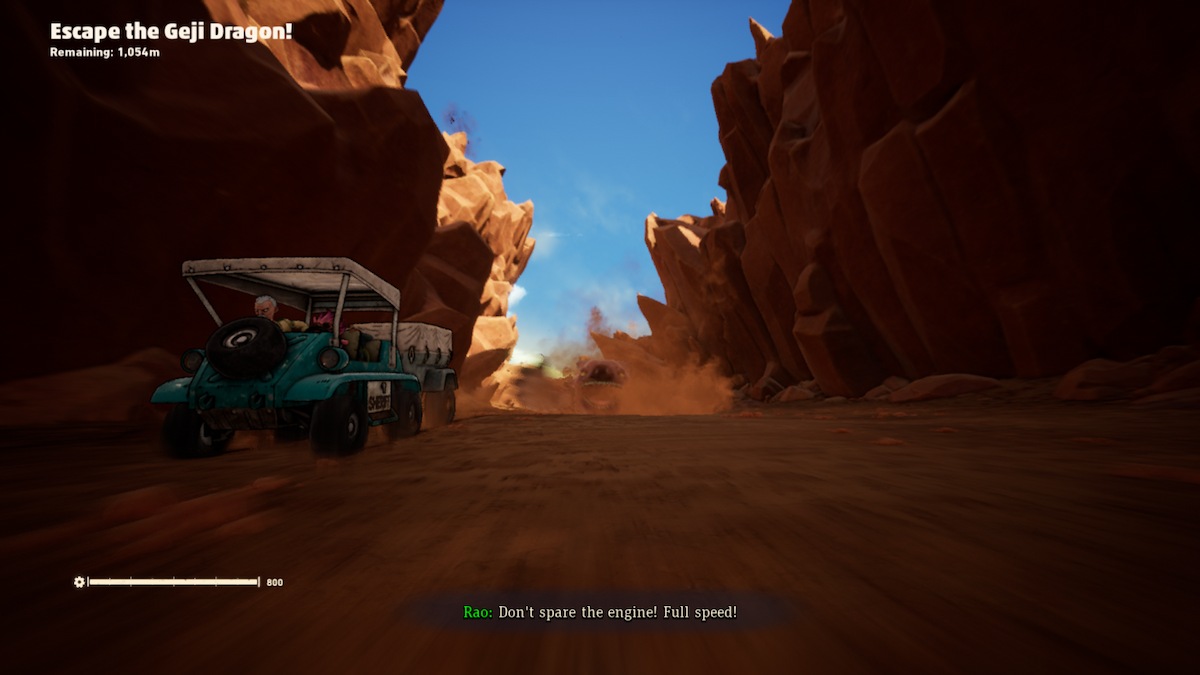Uma captura de tela de Sand Land, mostrando o início do "Fuja do Dragão Geji!" missão, com a criatura Dragão Geji à distância e um veículo verde à esquerda da estrada.  Existem penhascos imponentes em ambos os lados da estrada.