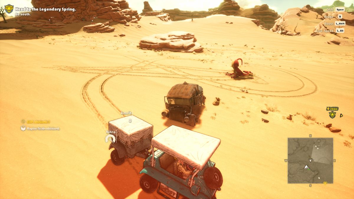 O veículo de Rao perto de um raptor vermelho morto deitado de bruços na areia com a traseira para cima.