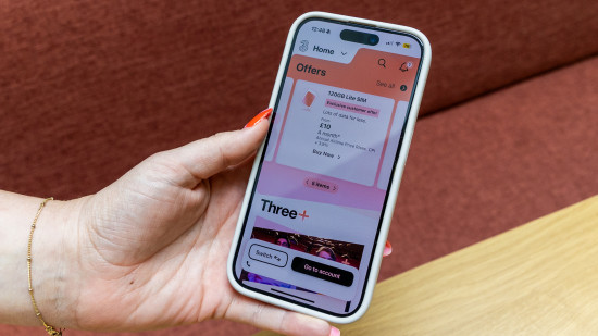 Mão de uma mulher segurando um iPhone com o aplicativo Three exibido