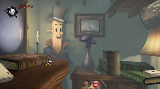 Captura de tela da análise do Epic Mickey Rebrushed mostrando um nível 2D em uma sala com uma mesa enorme, um livro e uma vassoura ao fundo