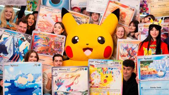 Recorde Mundial de Pokémon: Pikachu cercado por serpentinas segurando versões gigantes das cartas raras de arte em Surging Sparks